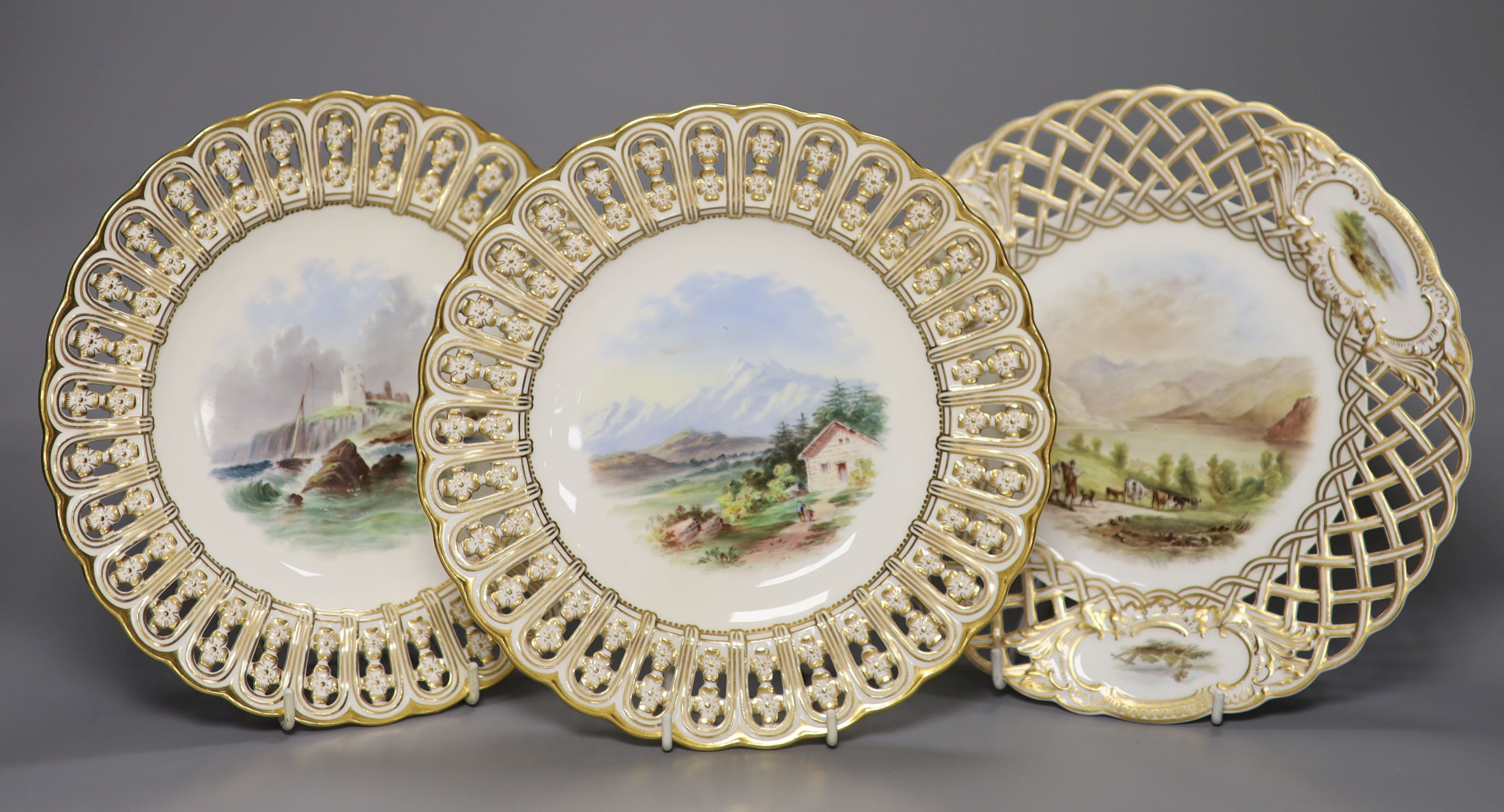 A pair of 19th century Minton pierced plates painted with landscapes, impressed marks, diameter 23cm, and a lattice work pierced plate